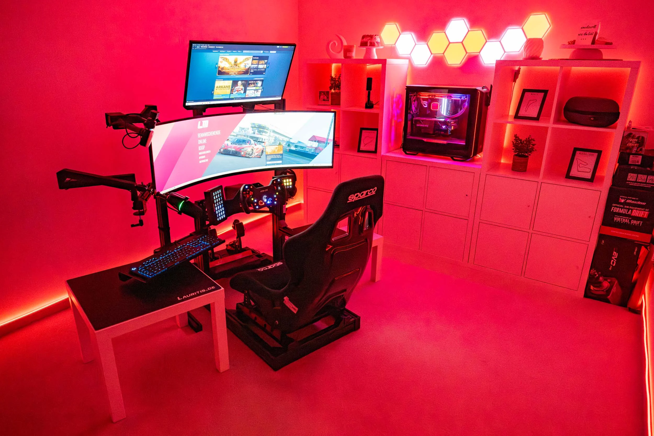 wwwpeterlauritisde | Lauritisde Red lit Racing game Setup Featuring a Curved Ultrawide Monitor Steering Wheel and Pedals Keyboard and a Sparco Chair Against a Workspace with White Shelves and a Glowing Hexagonal Led Wall Behind It