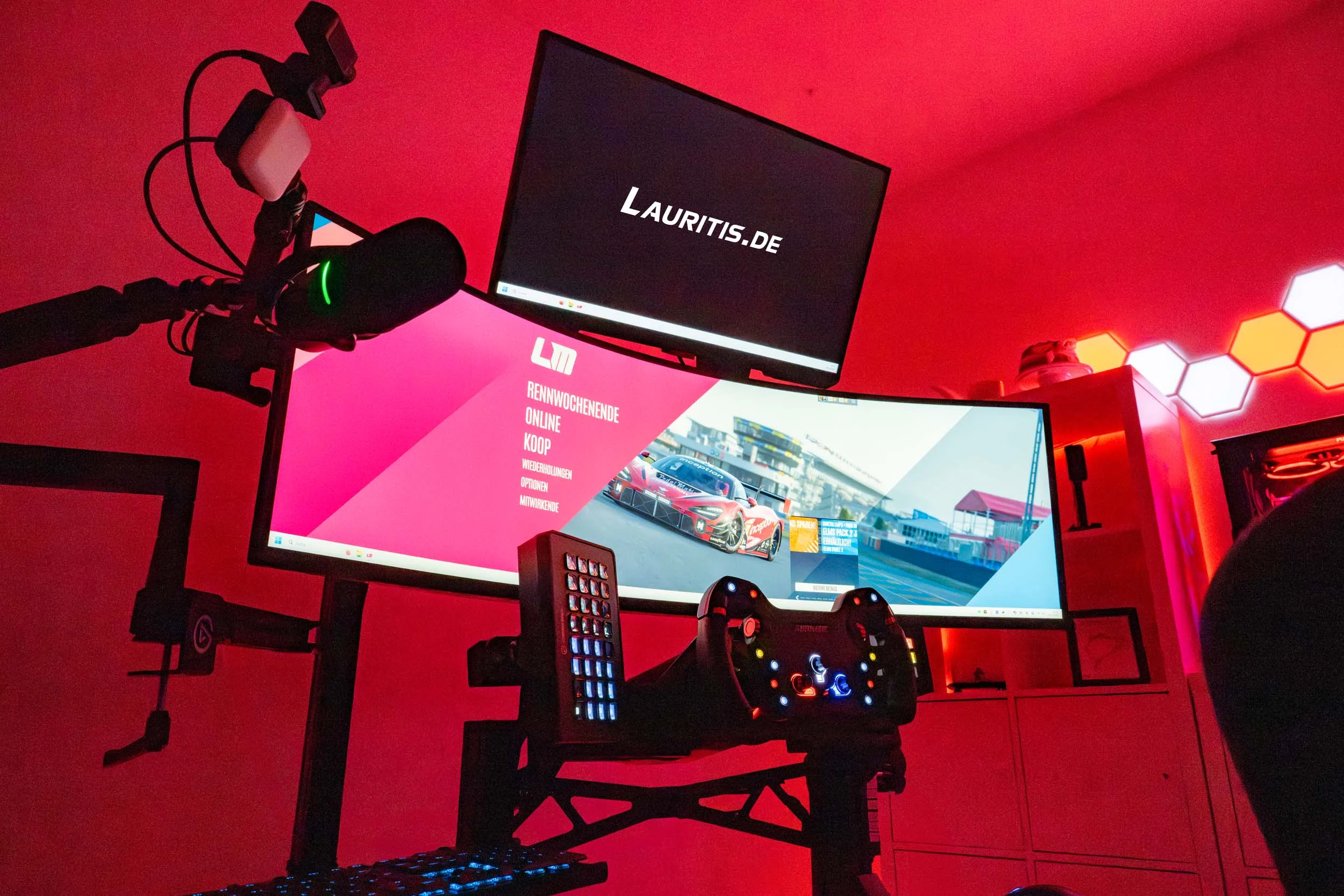 wwwpeterlauritisde | Lauritisde Gaming Desk Setup with Multiple Monitors and Red Ambient Lighting Racing Game on Main Screen and lauritisde Logo on Upper Monitor
