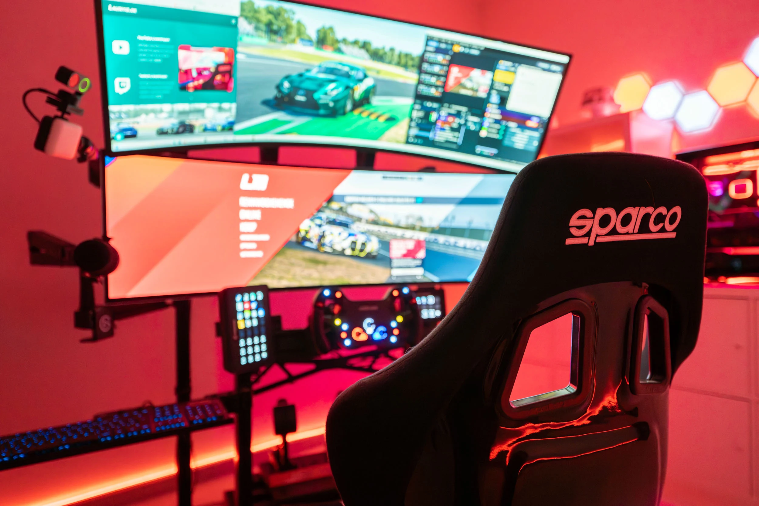wwwpeterlauritisde | Lauritisde Sleek Racing Computer Setup with a Curved Triple Monitor Display and a Sparco Racing Seat in Red Ambient Lighting Sim Racing Peripherals Visible